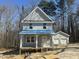 Two-story home with a front porch and a detached two-car garage, surrounded by trees at 1448B Maplewood Dr, Durham, NC 27704