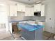 Well-lit kitchen featuring modern white cabinets, a subway tile backsplash, and an island at 1448B Maplewood Dr, Durham, NC 27704