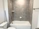 Bathroom with gray tiled shower, tub, and fixtures, complemented by neutral walls at 1448C Maplewood Dr, Durham, NC 27704