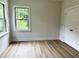 Bright bedroom boasts wood floors, neutral walls, a closet, and light-filled windows at 1448C Maplewood Dr, Durham, NC 27704