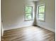 Bright bedroom features stylish wood floors, light walls, and windows offering views of the landscape at 1448C Maplewood Dr, Durham, NC 27704
