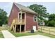 Exterior back of the home featuring a wooden porch with stairs and a newly constructed wooden fence at 1448C Maplewood Dr, Durham, NC 27704