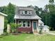 Charming two-story home with a modern metal roof, landscaped yard, and a welcoming entrance at 1448C Maplewood Dr, Durham, NC 27704