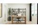 This modern home office features a wooden desk, chair, shelving unit, large windows, and ample natural light at 1542 Crescent Townes Way, Raleigh, NC 27604