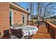 Outdoor back deck featuring table and chairs ideal for relaxing or entertaining with a brick home as backdrop at 1709 Shamrock Ln, Rocky Mount, NC 27804