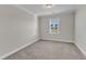 Neutral bedroom featuring a window, plush carpet and modern trim at 1776 Golden Honey Dr, Wake Forest, NC 27587