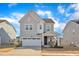 Charming gray two-story home featuring stone accents, a two-car garage, and beautifully landscaped front yard at 1776 Golden Honey Dr, Wake Forest, NC 27587