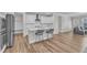 This open kitchen has an island with seating, white cabinets and stainless appliances at 1776 Golden Honey Dr, Wake Forest, NC 27587