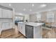 View of kitchen island with stainless dishwasher, open to a dining and living space at 1776 Golden Honey Dr, Wake Forest, NC 27587