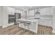 Bright kitchen features white cabinets, stainless appliances, an island with a breakfast bar and wood-look floors at 1776 Golden Honey Dr, Wake Forest, NC 27587