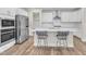 Modern kitchen showcases an island with seating, stainless appliances and white cabinets and countertops at 1776 Golden Honey Dr, Wake Forest, NC 27587