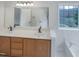 Bright bathroom with double vanity, soaking tub, and a view of the trees at 1908 Mystic Dr, Durham, NC 27712