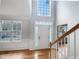 Bright foyer with soaring ceilings, hardwood floors, beautiful staircase, and large windows at 1908 Mystic Dr, Durham, NC 27712