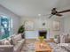 Bright living room featuring a fireplace, ceiling fan, hardwood floors, and comfortable seating at 1908 Mystic Dr, Durham, NC 27712
