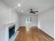 Open-concept living room featuring a fireplace, ceiling fan, and beautiful hardwood floors at 1908 Mystic Dr, Durham, NC 27712