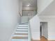 Bright staircase with hardwood steps, white risers, and natural light from windows at 1908 Mystic Dr, Durham, NC 27712
