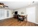 Living room with wood floors, ceiling fan, TV, dining table, and access to outdoor area at 2011 Quaker Lndg # 101, Raleigh, NC 27603
