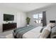 Bright bedroom featuring a large window, TV, modern dresser, and comfortable bed with stylish bedding at 2105 Attend Xing, Fuquay Varina, NC 27526
