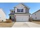 Charming two-story home with a two-car garage and neutral siding against a bright blue sky at 2105 Attend Xing, Fuquay Varina, NC 27526