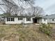 View of backyard featuring house with black shutters, fire pit, and leafless bushes at 215 Sallinger St, Knightdale, NC 27545