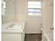 Bright bathroom featuring white tile walls, vinyl floors, and a vanity sink at 215 Sallinger St, Knightdale, NC 27545