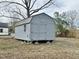 Exterior view of backyard shed featuring barn style roof, double doors, and small window on a leafy lawn at 215 Sallinger St, Knightdale, NC 27545