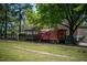 Exterior view of a red Southern train car with a wooden covered station next to a railroad track and green lawn at 215 Sallinger St, Knightdale, NC 27545