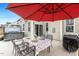 Backyard patio featuring a hot tub, dining area under a red umbrella, and outdoor cooking area at 244 W Copenhaver Dr, Clayton, NC 27527