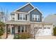 Charming two-story home featuring a two-car garage, covered porch with chairs, and neat front yard at 244 W Copenhaver Dr, Clayton, NC 27527
