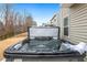 Modern hot tub with jets, situated on a backyard patio with surrounding trees and privacy fence at 244 W Copenhaver Dr, Clayton, NC 27527