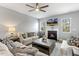 Comfortable living room features a fireplace, ceiling fan, and large windows for natural light at 244 W Copenhaver Dr, Clayton, NC 27527