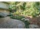 Backyard featuring a raised deck, lush greenery and a gravel area, blending nature and comfort at 3601 Swann St, Raleigh, NC 27612
