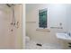 A bathroom featuring a standing shower, toilet, sink, and towel rack near the window at 3601 Swann St, Raleigh, NC 27612