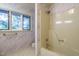 Bright bathroom features a shower-tub combo and a large window for natural light at 3601 Swann St, Raleigh, NC 27612