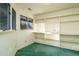 Bonus room featuring green carpet, built-in shelves, and abundant natural light from two windows at 3601 Swann St, Raleigh, NC 27612