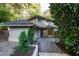 Home exterior featuring brick and wood with front door and lush landscaping and hardscape at 3601 Swann St, Raleigh, NC 27612