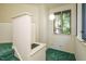 The hallway has green carpet and a double-hung window, allowing for natural light and ventilation at 3601 Swann St, Raleigh, NC 27612