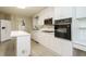 Spacious kitchen features white cabinetry, laminate countertops, and wood laminate flooring at 3601 Swann St, Raleigh, NC 27612