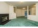 Bright living room featuring a fireplace, green carpet, and large windows at 3601 Swann St, Raleigh, NC 27612