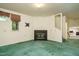 Inviting living space with fireplace, green carpeting, and view into kitchen at 3601 Swann St, Raleigh, NC 27612