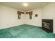 Open living area with a cozy fireplace, carpet flooring, and natural light from windows at 3601 Swann St, Raleigh, NC 27612