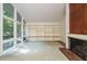 Inviting living room with large windows, built-in shelves, and a charming brick fireplace at 3601 Swann St, Raleigh, NC 27612
