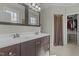 Bathroom with a double vanity, dark wood cabinets, and a walk-in closet at 3741 Manly Farm Rd, Wake Forest, NC 27587