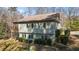 Back exterior of home with a deck on a lush lot, featuring mature trees and landscaping at 3741 Manly Farm Rd, Wake Forest, NC 27587