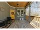 Relaxing front porch with wooden floors, yellow door, and charming decor at 3741 Manly Farm Rd, Wake Forest, NC 27587