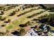 Aerial view of a well-manicured golf course with lush green fairways and strategically placed trees and water features at 404 Carpels Dr, Wendell, NC 27591
