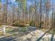 A welcoming driveway and landscaped entrance with split rail fencing offer a charming approach to this wooded retreat at 405 Lookout Pt, Rougemont, NC 27572