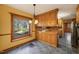 Well-lit kitchen with wood cabinets, tile flooring, and a bright window providing natural light and views of the outdoors at 405 Lookout Pt, Rougemont, NC 27572