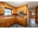 Functional kitchen with wood cabinets, stainless steel microwave, and tile floors, adjacent to a hallway at 405 Lookout Pt, Rougemont, NC 27572