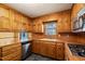 Cozy kitchen with wood cabinets, modern appliances, and a window overlooking a serene wooded area at 405 Lookout Pt, Rougemont, NC 27572